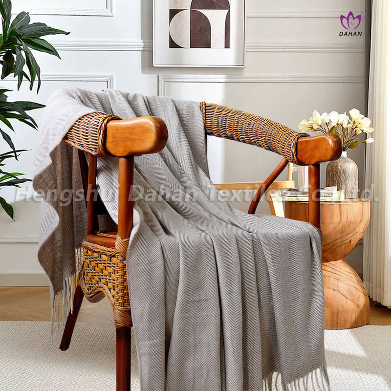 Herringbone pattern blanket with tassels.